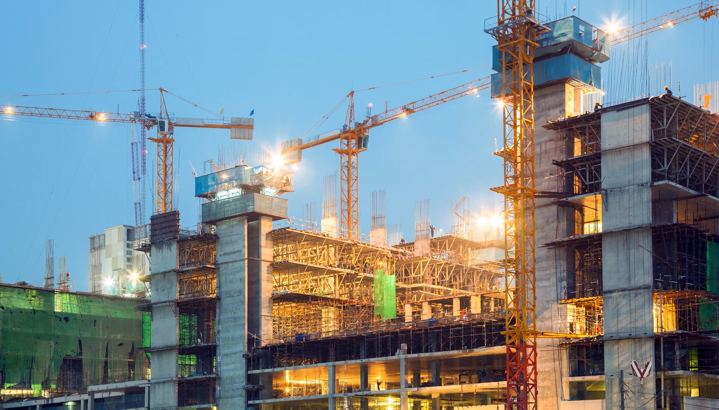 Cranes over a construction site at sunset
